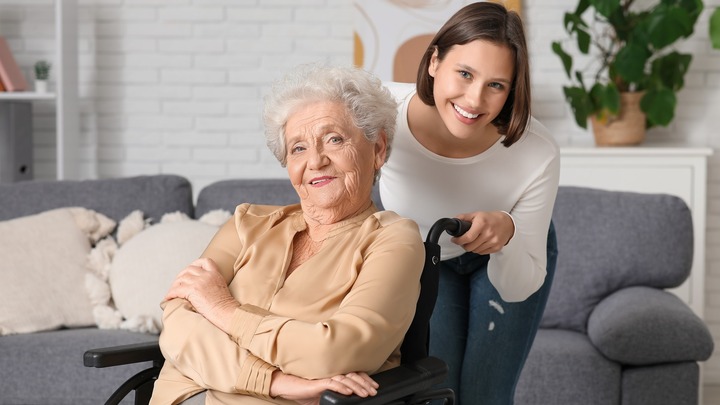 Seniorin im Rollstuhl und junge Frau haben gute Laune